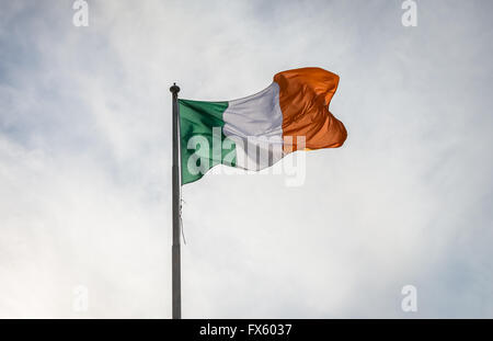 Die irische Trikolore fliegt von Fahnenstange. Die Nationalflagge von Irland. Stockfoto