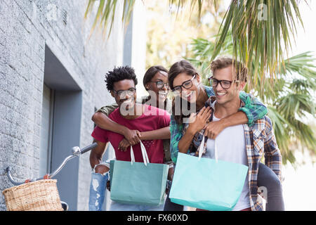 Junge Männer geben Frauen Huckepack Stockfoto