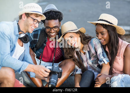 Mann, die Anzeige von Fotos in der Kamera zu seinen Freunden Stockfoto