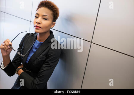 Gemischte Rassen Geschäftsfrau hält Brillen Stockfoto