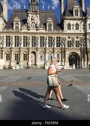 Zwei Touristen zu Fuß vor Hotel De Ville in Paris, als Sonne nach unten ging Stockfoto