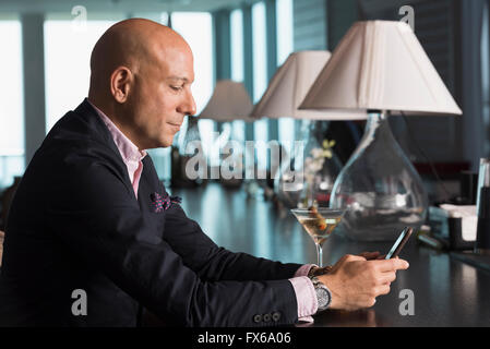 Kaukasische Geschäftsmann mit Handy in der Bar Stockfoto