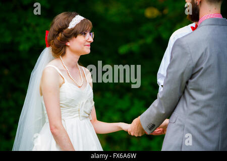 Braut und Bräutigam die Ringe bei einer Hochzeitszeremonie wechseln. Stockfoto