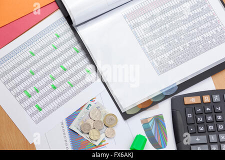 Finanziers desktop zeigt zwei Berichte über die Verkäufe mit einem Taschenrechner und Bargeld lose Verlegung auf einem Diagramm Ausdruck beschäftigt Stockfoto