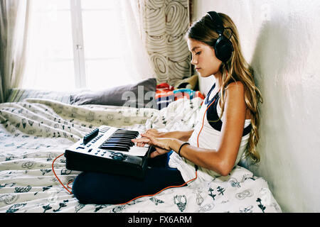 Indianer Mädchen spielen Tastatur auf Bett Stockfoto