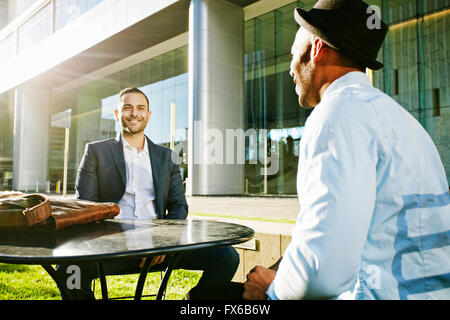 Unternehmer im Gespräch am Tisch im freien Stockfoto