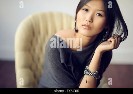 Asiatische Frau im Sessel sitzen Stockfoto