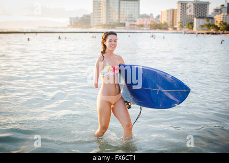 Gemischte Rassen Amputierte mit Surfbrett im Ozean Stockfoto