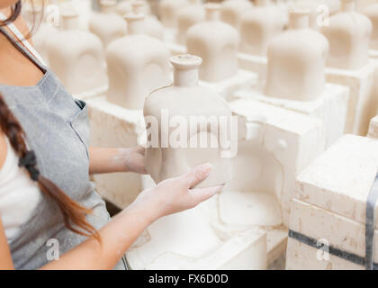 Lateinamerikanische Künstler halten Vase und Schimmel im studio Stockfoto