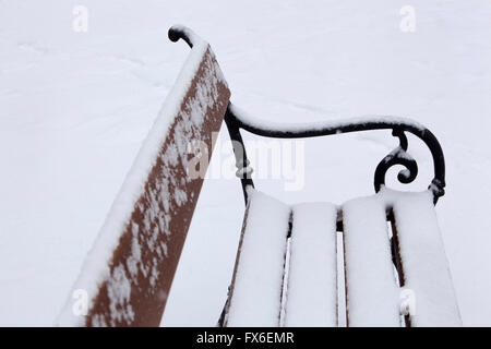 Schneebedeckte Bank in der Parkbank Stockfoto