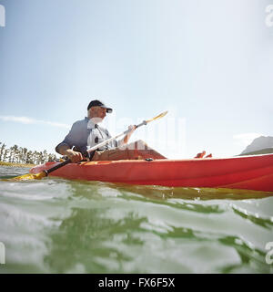 Schuss von senior woman Kajak auf See an einem Sommertag. Reifer Mann eine Kajak in See paddeln. Stockfoto