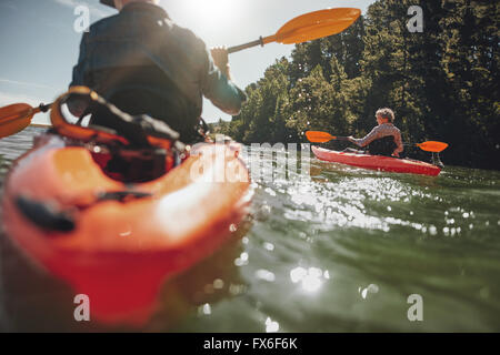 Porträt von Reife Frau Kajak in See an einem sonnigen Tag. Paar am Sommertag in einem See Kanu. Stockfoto