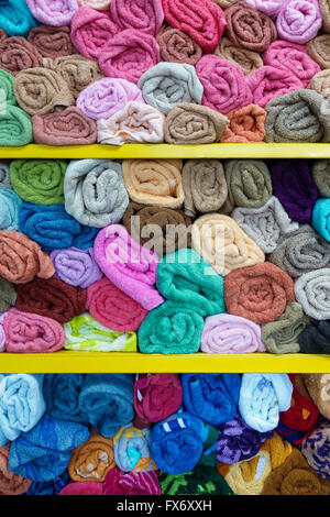 Bunte Handtücher auf Regalen in einem Geschäft gerollt Stockfoto