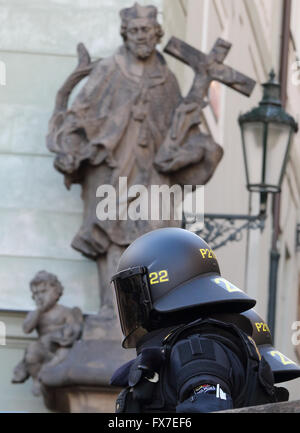 behelmte Aufruhr Polizist unter einem religiösen Statue in Prag während Protest gegen Präsident Xi Chinas Besuch auf 30.03.16 Stockfoto