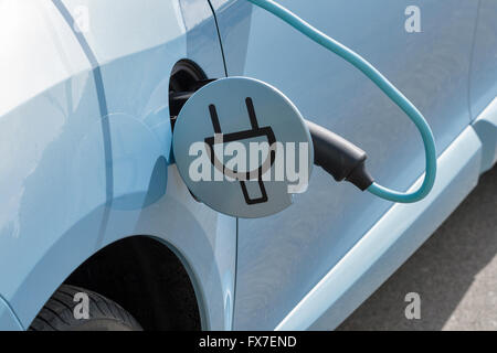 Laden, die ein Elektroauto mit dem Netzteil-Kabel eingesteckt, Nahaufnahme Stockfoto