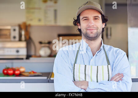 Inhaber eines kleinen Unternehmens lächelnd vor seiner Speisen zum mitnehmen Stockfoto