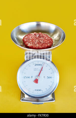 Retro-Küchenwaage mit frischem Hackfleisch rot wird gewogen Stockfoto