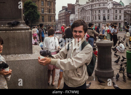 Archivbild eines jungen Mannes, der die Tauben auf dem Trafalgar Square, London, England, im Jahr 1986 füttert. Vogelfütterung wurde 2003 von dem Londoner Bürgermeister Ken Livingstone verboten. Stockfoto