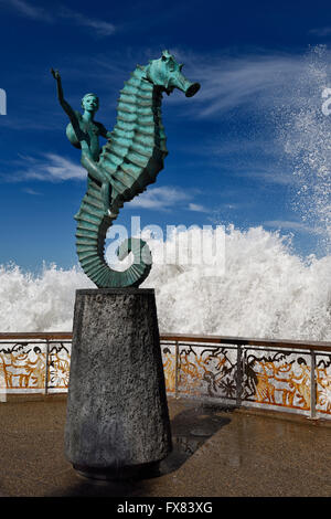 Junge auf ein Seepferdchen auf Puerto Vallarta Malecon mit Spritzer Ozeanwelle Stockfoto