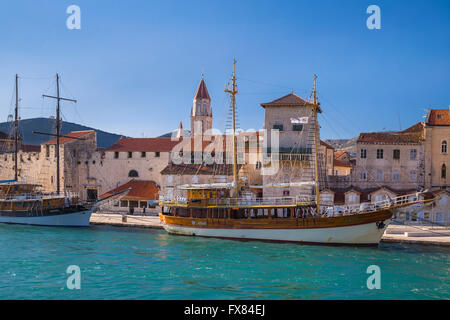 Zwei große Segelboote sind entlang der Uferstraße in Trogir, Crotis vertäut. Im Hintergrund ist den Glockenturm zu sehen Stockfoto