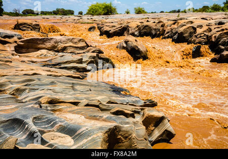 Lugards fällt am Galana River im Tsavo National Park East Kenia gefärbt rot mit Schlick nach starkem Regen Stockfoto