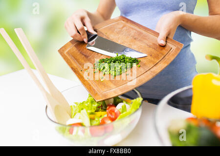 Nahaufnahme von Frau mit gehackten Zwiebeln Kochen Salat Stockfoto