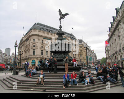 Touristen sitzen auf den Stufen der Shaftesbury-Gedenkbrunnen am Piccadilly Circus. Stockfoto