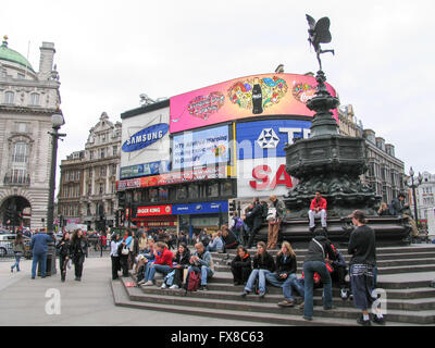 Touristen sitzen auf den Stufen der Shaftesbury-Gedenkbrunnen am Piccadilly Circus. Stockfoto