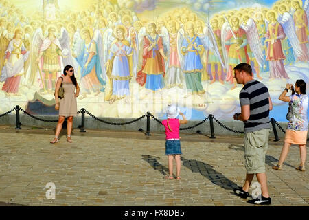 Touristen machen Fotos außerhalb ein Wandbild am Eingang Mikhailovsky Kathedrale in Kiew Stockfoto