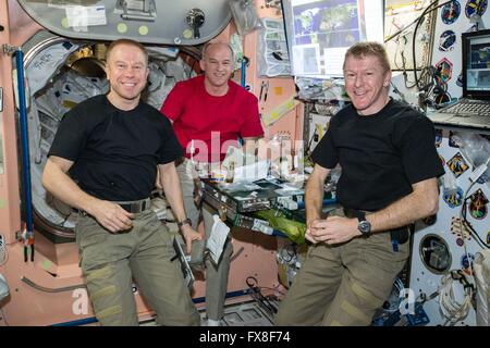 Internationale Raumstation ISS-Expedition 47 Besatzungsmitglieder amerikanischen Astronauten Tim Kopra (links) und Jeff Williams verbinden britische Astronaut Tim Peake zum Abendessen im Unity-Modul 5. April 2016 in der Erdumlaufbahn. Stockfoto