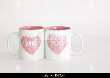 Zwei weiße Kaffeebecher mit einem Herz-Logo gedrängt beieinander Rechtschreibung ' mir Sie ". Auf einem reinen weißen Hintergrund isoliert Stockfoto