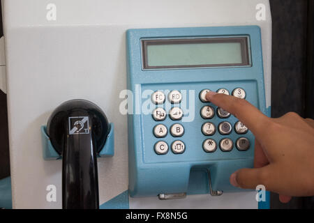 Nahaufnahme der Hand Drücken von Tasten zu öffentliches Telefon Stockfoto
