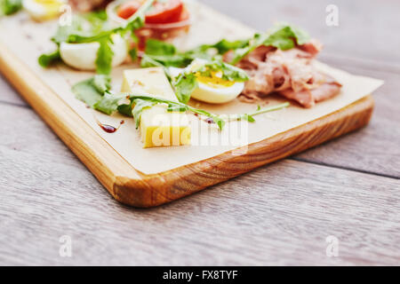 Frischer Salatteller mit Schinken, Ei, Rucola und Käse Stockfoto