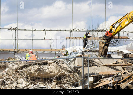 Haus-Abriss mit einem schweren beweglichen Bagger Stockfoto