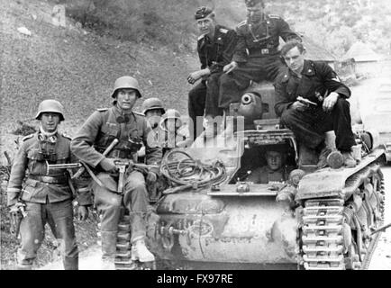 Das Bild der Nazi-Propaganda zeigt Soldaten der deutschen Wehrmacht auf einem gefangenen Panzer während des Vormarsches in Jugoslawien im April 1941. Fotoarchiv für Zeitgeschichtee - KEINE ÜBERWEISUNG - Stockfoto