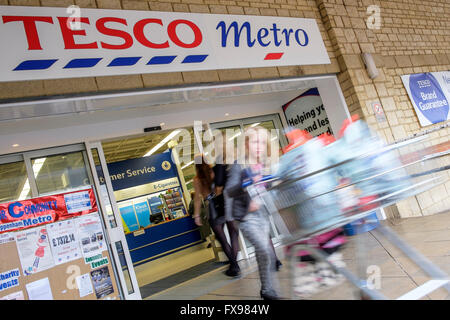 Chippenham, UK. 12. April 2016. Am Tag bevor Tesco es volle meldet sind Jahr Ergebnisse Shopper am Eingang des Tesco Metro Supermarkt in Chippenham, Wiltshire abgebildet. © Lynchpics/Alamy Live-Nachrichten Stockfoto