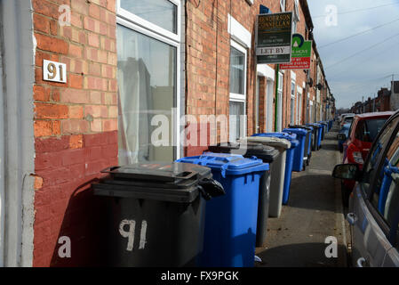 Haushalt Müllabfuhr Mülleimer sind einem ständigen Anblick auf dem Fußweg in Havelock Road, Kettering, Northamptonshire. Stockfoto