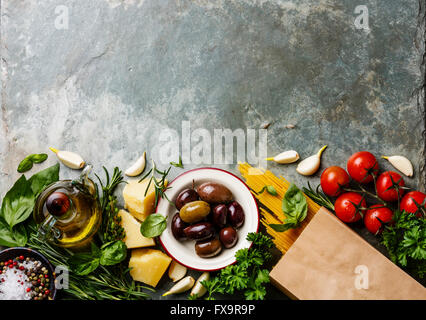 Italienische Küche Zutaten Hintergrund mit Spaghetti, Parmesan, Oliven, Öl und Basilikum Stockfoto