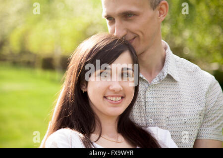 Liebespaar auf ein Datum, junge Mann zärtlich umarmt seine glücklich lächelnde Freundin Stockfoto