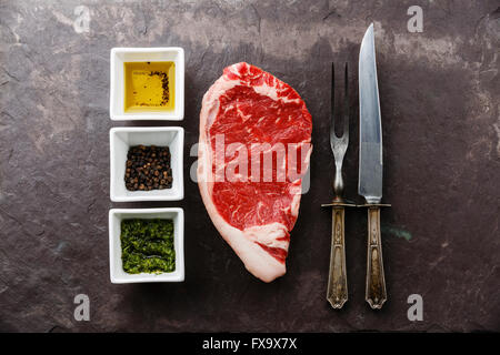 Rohe marmorierte Frischfleisch Striploin Steak und Gewürze auf Stein Schiefer-Hintergrund Stockfoto