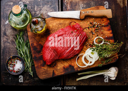 Rohes Frischfleisch Filet und Gewürze auf dunklem Hintergrund Stockfoto