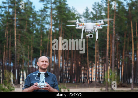 Mann mit seinem Outdoor-Drohne mit Wald-Hintergrund Stockfoto