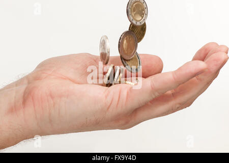 Seite-Detail-Ansicht in eine männliche Hand der fallende EURO-Münzen vor einem weißen Hintergrund Stockfoto