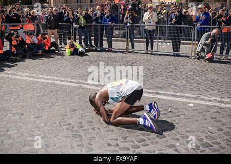 Rom - 10. April 2016: Amos Kipruto unmittelbar nach die Zeile in der Via dei Fori Imperiali vor der Öffentlichkeit kniet Stockfoto