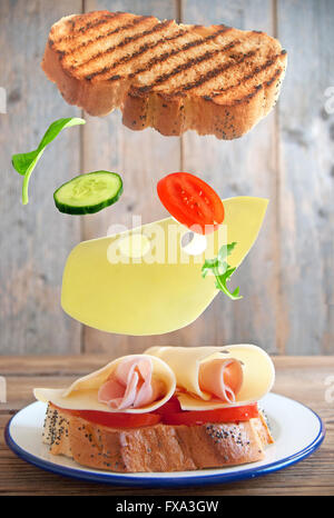 Sandwich-Zutaten fallen an ihren Platz auf einem Teller Stockfoto