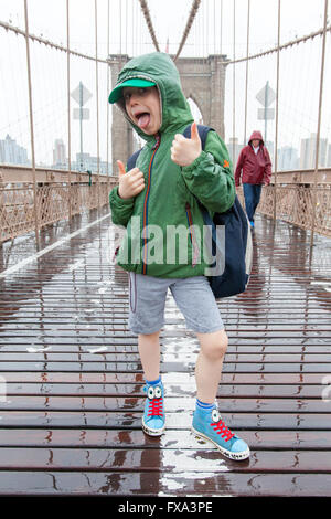 Sechs Jahre alter Junge auf der Brooklynbridge im Regen, New York City, Vereinigte Staaten von Amerika. Stockfoto