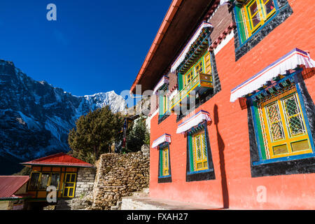 Farbenfrohe Gebäude des Klosters Thame Gompa, liegt an einem Berghang, Schnee bedeckte Berge in der Ferne, Thame Stockfoto