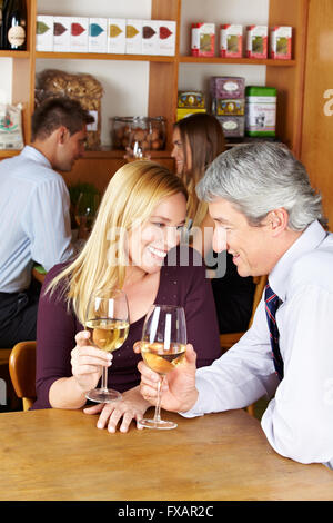 Ältere glückliches Paar mit Glas Weißwein in einem Café sitzen Stockfoto