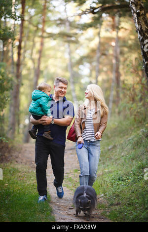 Glückliche Familie mit Waschbär zu Fuß in einem Wald Stockfoto