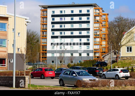 Ronneby, Schweden - April 7, 2016: 8-stöckiges, schwarzen und weißen Gebäude mit orangen Balkonen. Parkplatz vor. Stockfoto